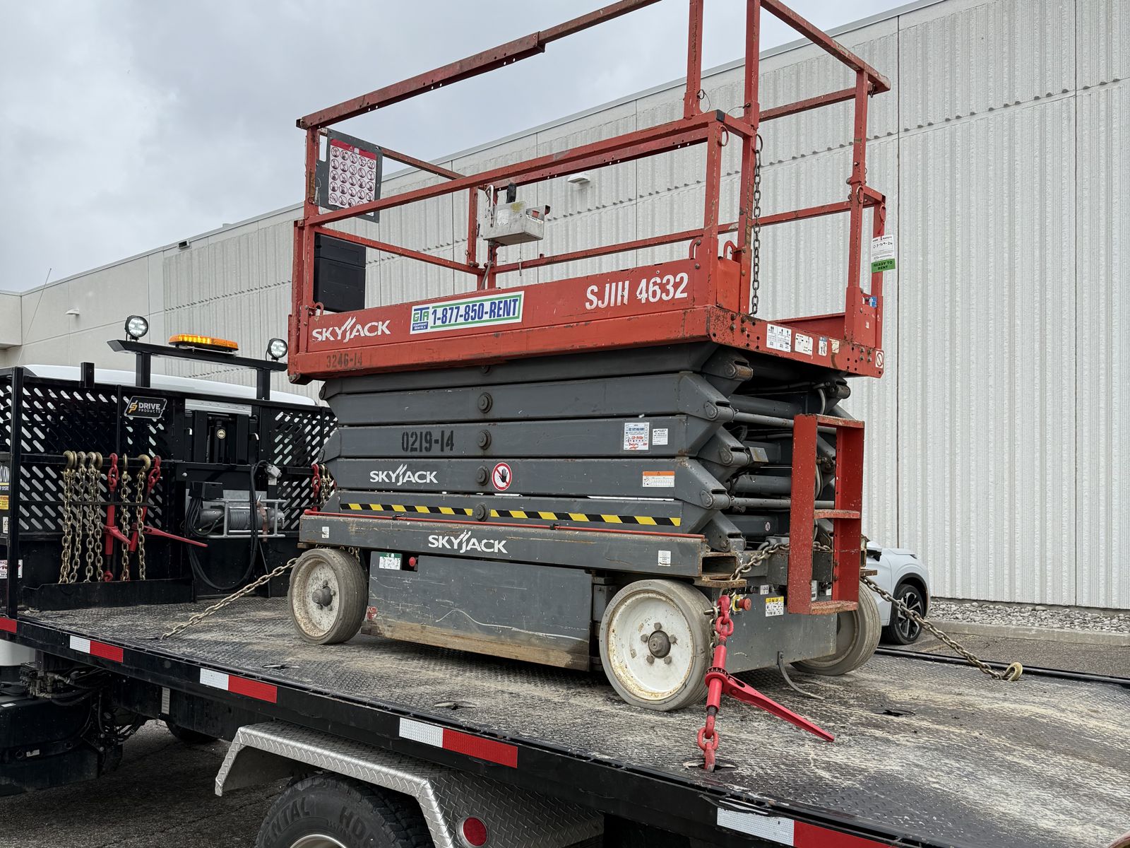 Skyjack SJ4632 electric scissor lift from GTA Equipment Rentals chained down on the float, ready for delivery in the west GTA