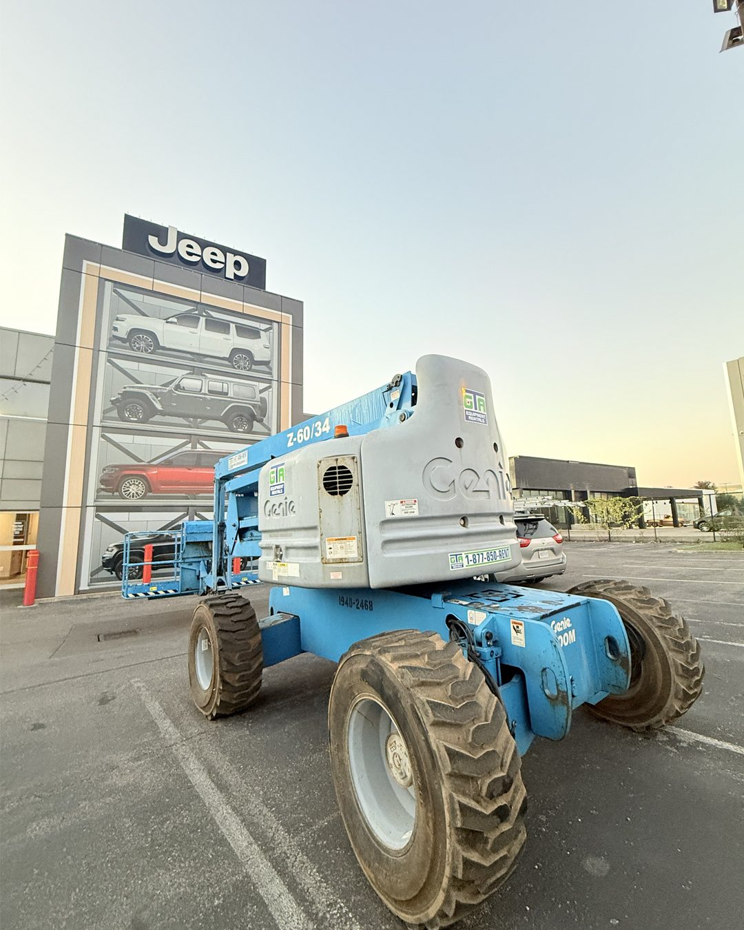 Genie articulating boom lift working at a car dealership
