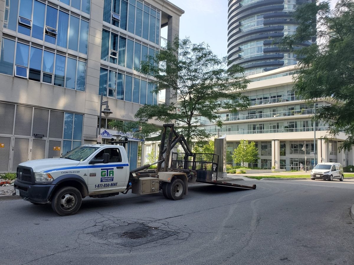 GTA Equipment Rentals truck delivering a scissor lift to a Milton jobsite