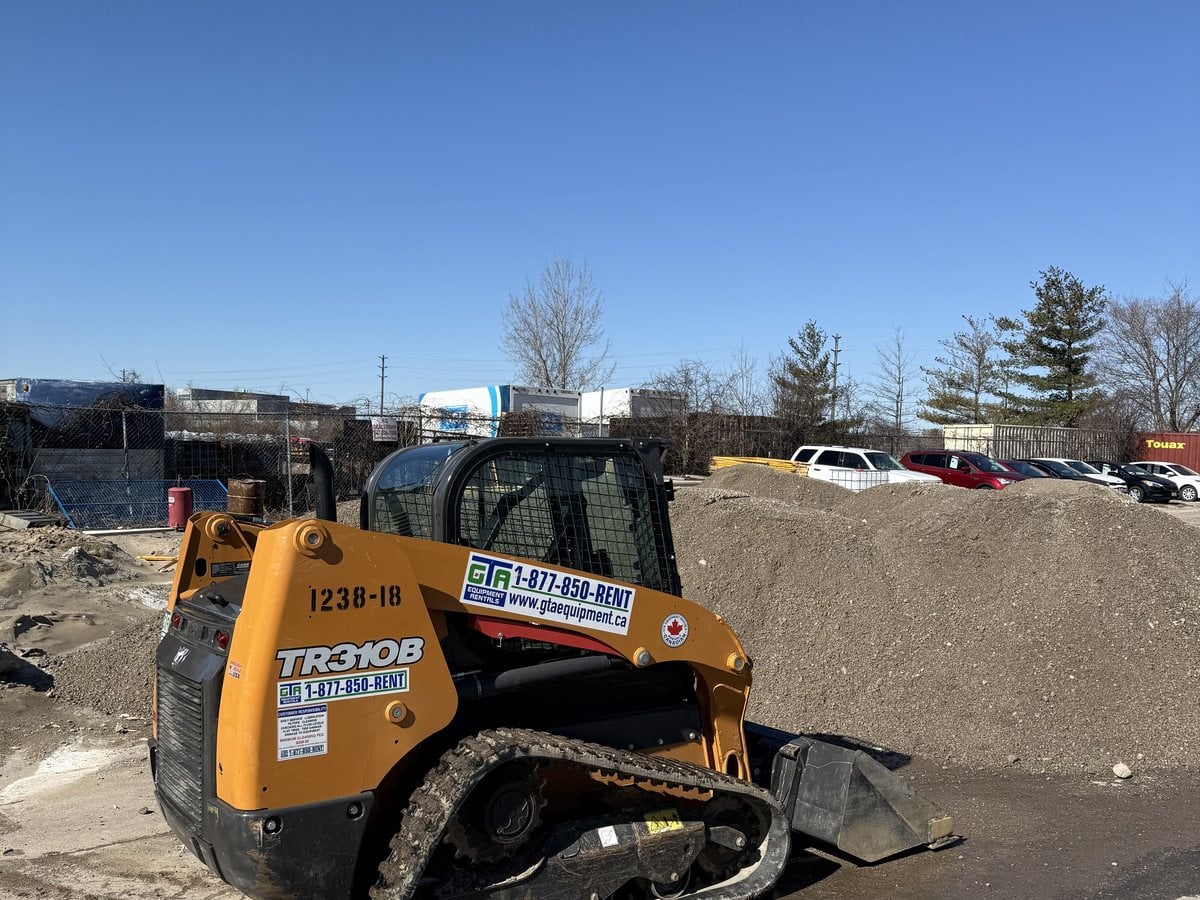 Compact track loader working on soft ground on a GTA job site