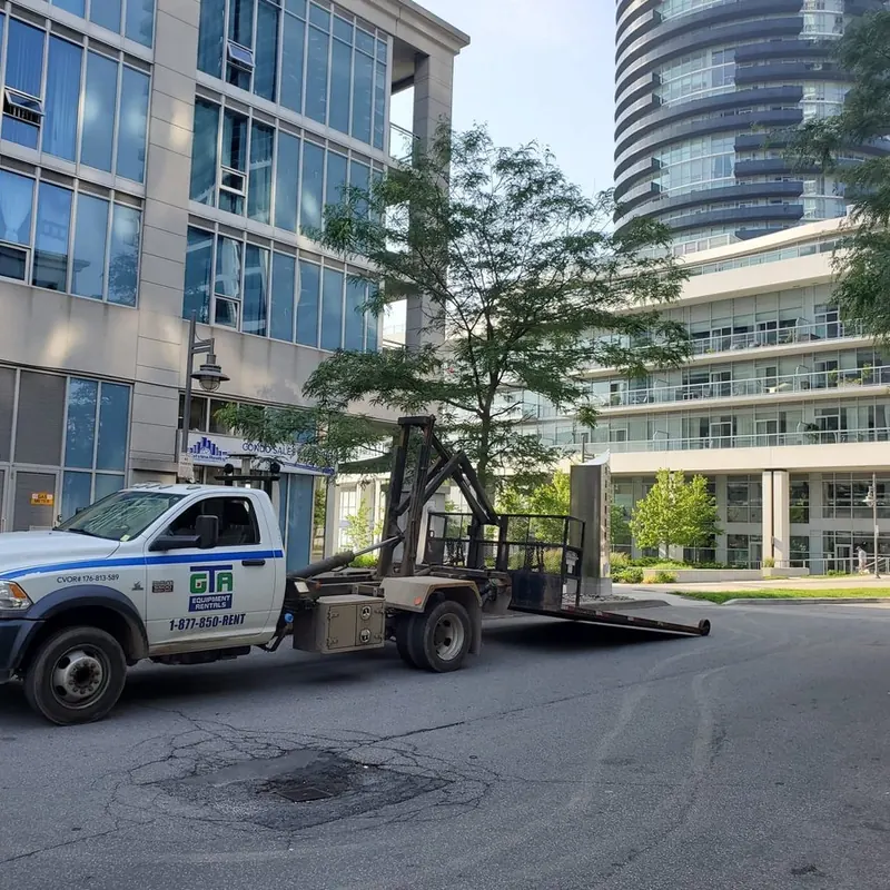 GTA Equipment Rentals float truck delivering a machine to a Toronto jobsite